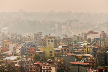 View of Kathmandu capital of Nepal from mountain through urban haze with lot of low rise buildings, cityscape creating an ethereal atmosphere in mountain air, Kathmandu air pollution