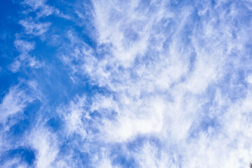 Blue sky with wispy cirrus clouds conveying a sense of tranquility and spaciousness, ideal for backgrounds.