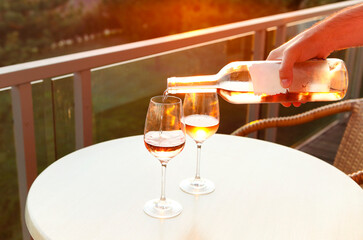 Two glasses and bottle of rose wine in the evening on terrace