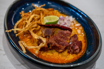 Khao Soi, Thai northern style curried noodle soup with meat served in a bowl