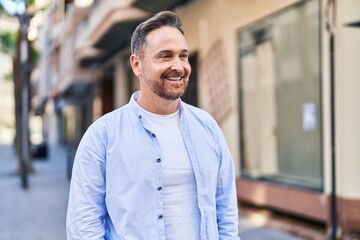 Fototapeta premium Young caucasian man smiling confident looking to the side at street