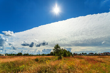 Summer village landscape with beautiful clouds.