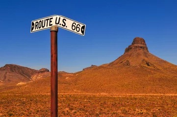 Zelfklevend Fotobehang A bent road sign on the Historic Route 66 through the harsh desert terrain between Kingman and the wild west gold mining town of Oatman, Arizona, Southwest USA. © Pedro