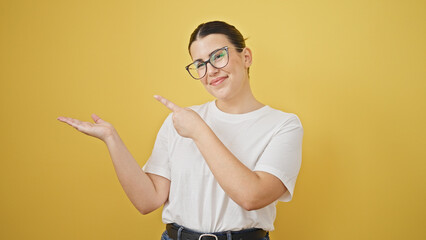 Young beautiful hispanic woman smiling pointing to the side over isolated yellow background