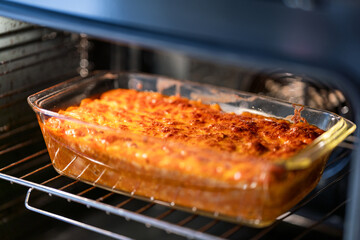 removing finished lasagna from oven