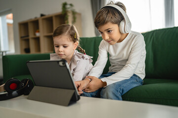 Brother sister siblings use digital tablet at home watch online video