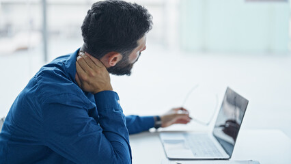 Young hispanic man business worker suffering for cervical pain working at the office