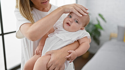 Mother standing with daughter on arms at home