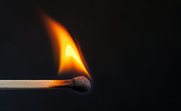 Burning wooden match on black background.