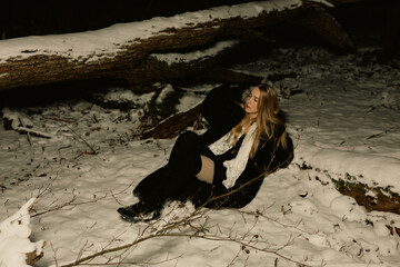 young blond woman with blue eyes dancing in the dark night of an very cold snow winter