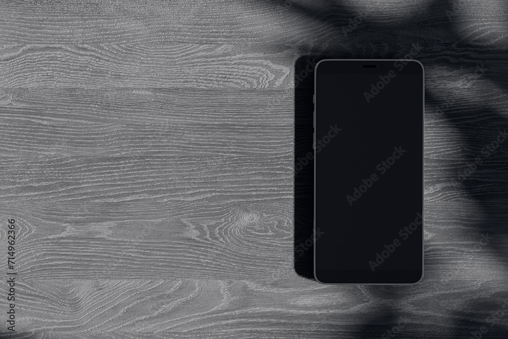 Poster Close up of empty cellphone on dark wooden surface with leaf shadows. Presentation concept. Mock up, 3D Rendering.