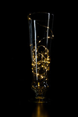 vase transparent avec une guirlande lumineuse à l'intérieur devant un fond noir 