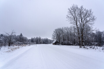 Winter landscape in the countryside - a road, a house by the side of the road