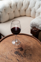 Glass with red wine on wooden table. merlot wine background