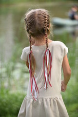 Little girl with braids and ribbons in her hair.