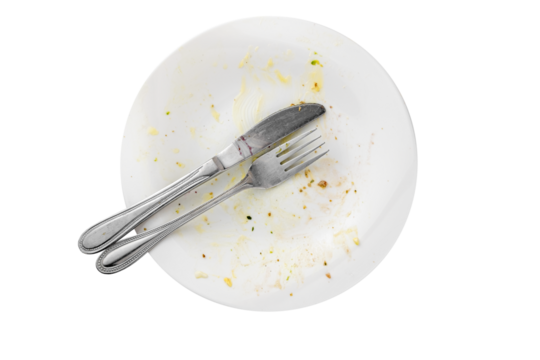 Empty dirty food plate with knife and fork isolated, table top view