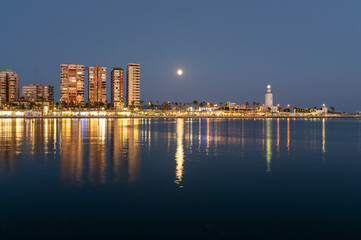 Malaga, Spanish town, coastal area with lighthouse at night