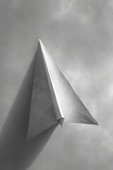 A depiction of a minimalist paper airplane, partially unfolded, revealing its simple construction,