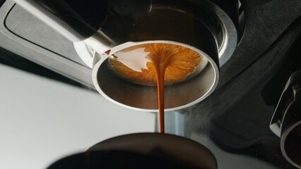 Coffee espresso machine pulling double shot espresso from bottomless naked portafilter. 