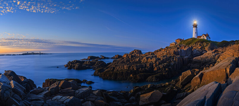 panoramic photo of a lighthouse on a rocky coast in the early evening