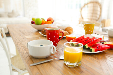 Coffee with fruit, cereal and croissant on wooden table background