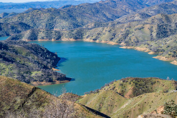 Aerial view of Lake Berryessa from the Blue Ridge Trail, Stebbins Cold Canyon, on a sunny day, featuring the surrounding blue oak woodland and the cove marina