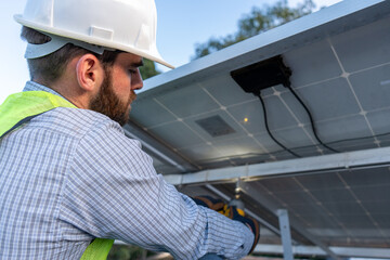 engineer installing and giving maintenance to solar panels, concept of renewable energy power, professional technician working below solar panel, beneath power station