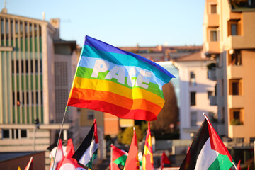 peace flag and other flags, including the Palestinian one, with the word PACE in Italian flying during the demonstration