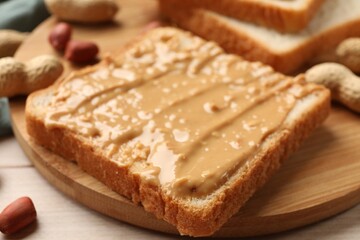 Delicious toast with peanut butter on table, closeup