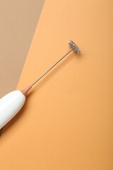 White milk frother wand on color background, top view