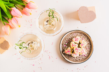 Cocktails with rosemary in glasses and candy hearts on a plate for Valentine's day top view