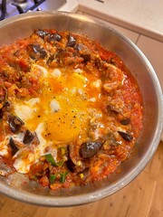 pan with shakshuka, fried eggs in tomatoes, shakshuka with eggplants, eastern dish, tomato sauce with eggplants
