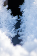 Ice crystals macro in close-up view shows beautiful ice structures of frozen water with spikey crystals and elegant snowflakes after winter snowfall in arctic climate with cold temperatures crackling