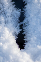 Ice crystals macro in close-up view shows beautiful ice structures of frozen water with spikey crystals and elegant snowflakes after winter snowfall in arctic climate with cold temperatures crackling