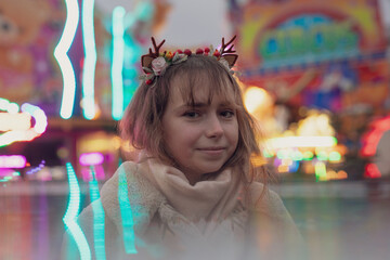 young cosplay woman on fun fare and Ferris wheel with magic winter lights