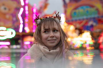 Fototapeta premium young cosplay woman on fun fare and Ferris wheel with magic winter lights