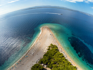 Aerial drone view of a beautiful sunny beach at Adriatic sea with palms and boat. Vacation background