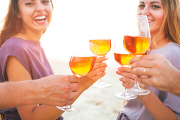 People holding glasses of wine and talking at the beach picnic