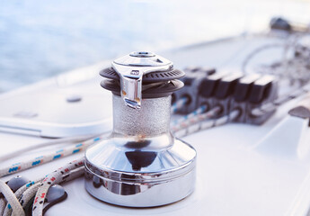 Sailboat detailed parts. Close up on winch and rope of yacht over blue sea