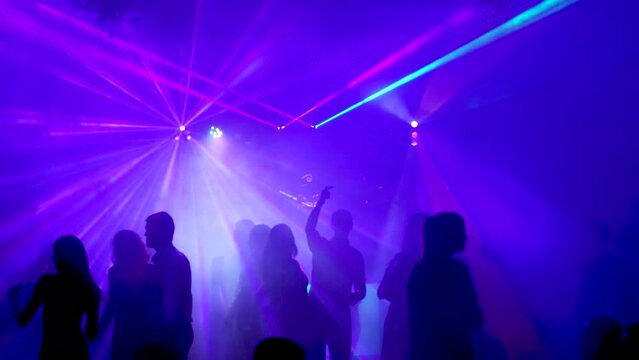 Nightclub. Ibiza June 2018. Young people dance and have fun at a party with bright illumination and a light laser show.