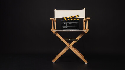White director chair with clapper board on black background