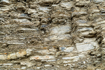 Cross section of a mountain wall, showing layers of sediment and rock.