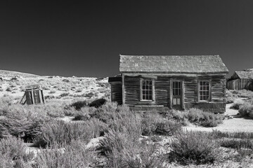 Abandoned desert ghost town cabin in the ghost town of Bodie State Park California, USA. Converted to classic black and white art finish.