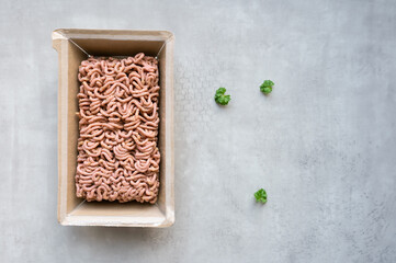 Minced plant-based meat in packaging on a gray background.
