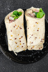 wrap ham, vegetable, cheese, lettuce tortilla fresh tasty eating cooking appetizer meal food snack on the table copy space food background rustic top view