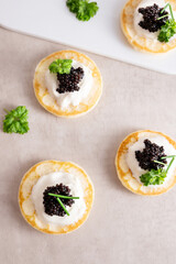 Top view of appetizer, black caviar with pancake and sour cream.