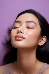 An Asian girl is smiling at something with her eyes closed. dreams and dreams, meditation and self-development. lavender background.