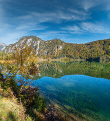 Fototapeta na wymiar Peaceful autumn Alps mountain lake with clear transparent water and reflections. Almsee lake, Upper Austria.