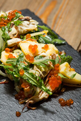 salad with arugula, red caviar and potato