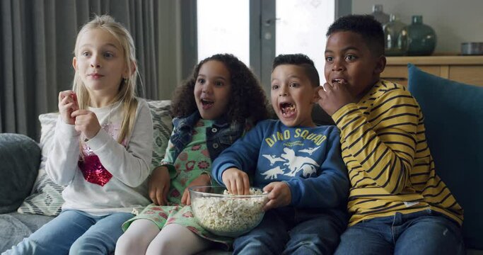 Children, surprised and movie on sofa with popcorn for relax, horror and watching tv in living room of home. Kids, group and streaming show, film or cartoon with snack, shouting or shocked on couch